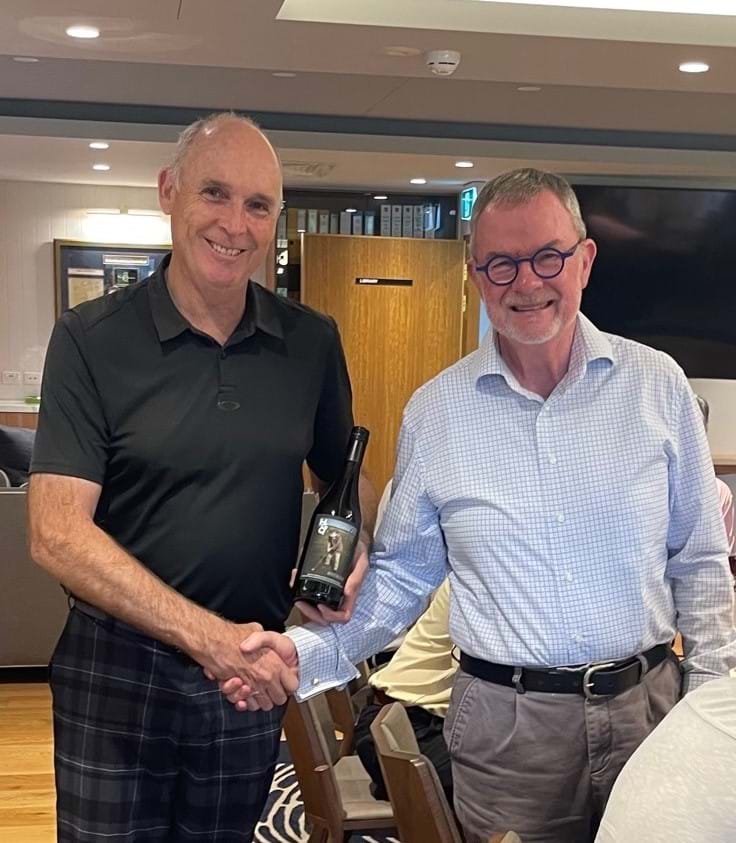 Greg Cooper accepting the wine from Secretary Akes